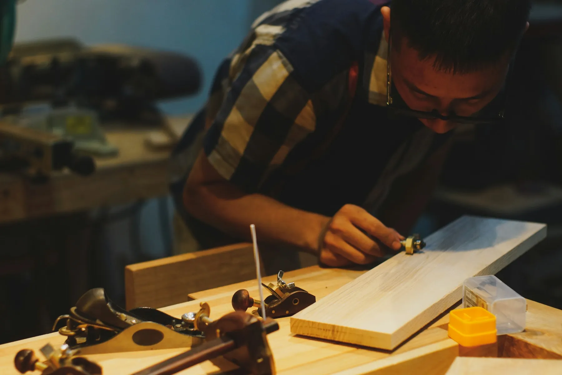 Menuisier travaillant une planche au rabot dans un atelier